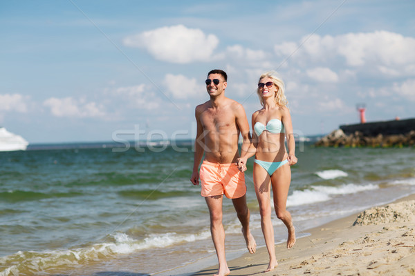 happy couple in swimwear running on summer beach Stock photo © dolgachov