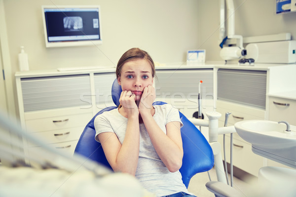 Stock photo: scared and terrified patient girl at dental clinic
