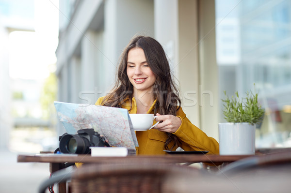 happy woman with map drinking cocoa at city cafe Stock photo © dolgachov