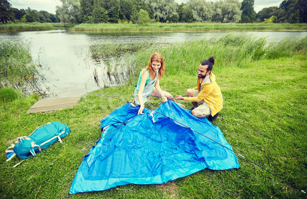 happy couple setting up tent outdoors Stock photo © dolgachov