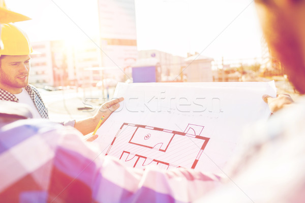 close up of builders with blueprint at building Stock photo © dolgachov