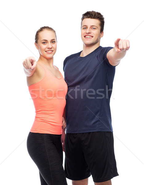 happy sportive man and woman pointing finger Stock photo © dolgachov