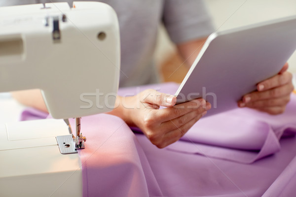 tailor with sewing machine, tablet pc and fabric Stock photo © dolgachov