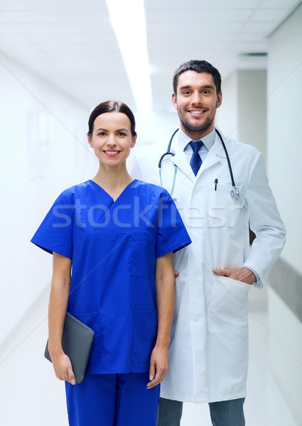 smiling doctor in white coat and nurse at hospital Stock photo © dolgachov