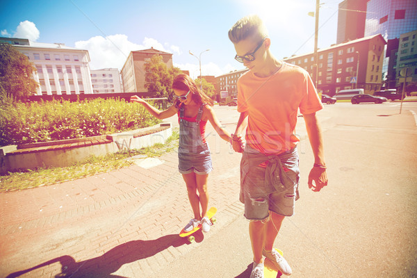teenage couple riding skateboards on city street Stock photo © dolgachov
