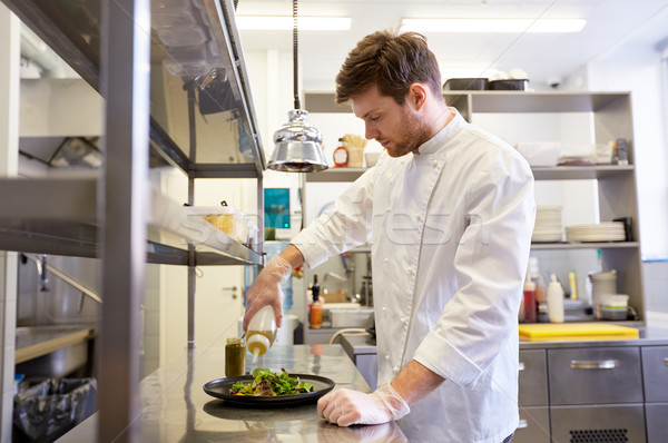 happy male chef cooking food at restaurant kitchen Stock photo © dolgachov