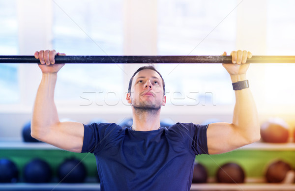 man exercising on bar and doing pull-ups in gym Stock photo © dolgachov