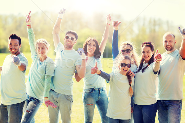 group of volunteers showing thumbs up in park Stock photo © dolgachov