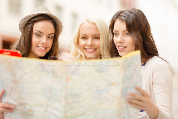 beautiful girls looking into tourist map in city Stock photo © dolgachov