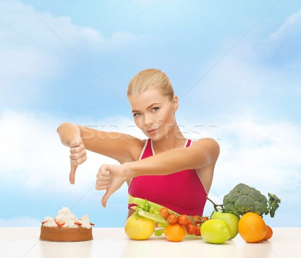 woman with fruits showing thumbs down to cake Stock photo © dolgachov