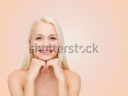 smiling young woman touching her face skin Stock photo © dolgachov