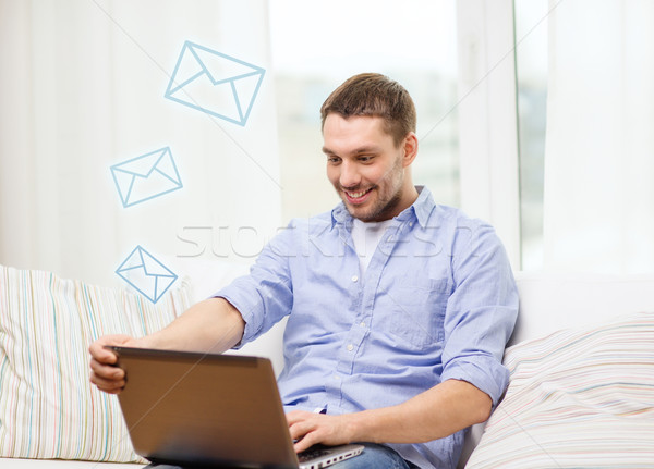 smiling man working with laptop at home Stock photo © dolgachov