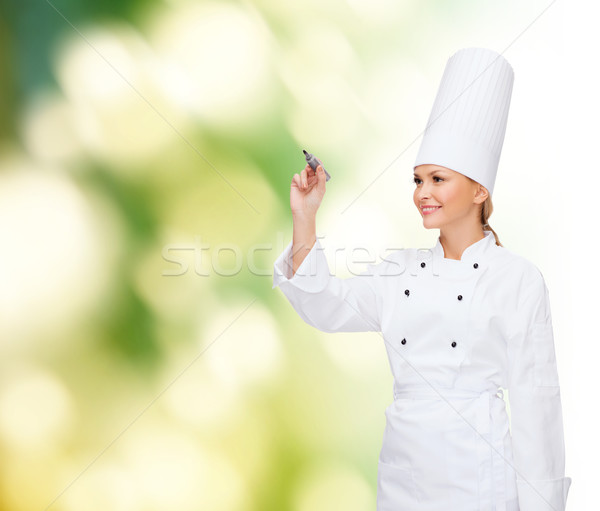 smiling female chef writing something on air Stock photo © dolgachov