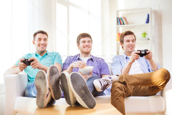 Glimlachend vrienden spelen video games home vriendschap Stockfoto © dolgachov