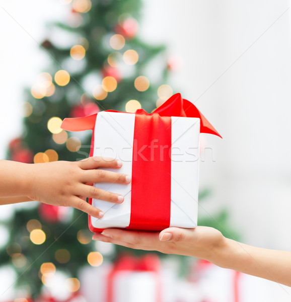 Stock photo: close up of child and mother hands with gift box