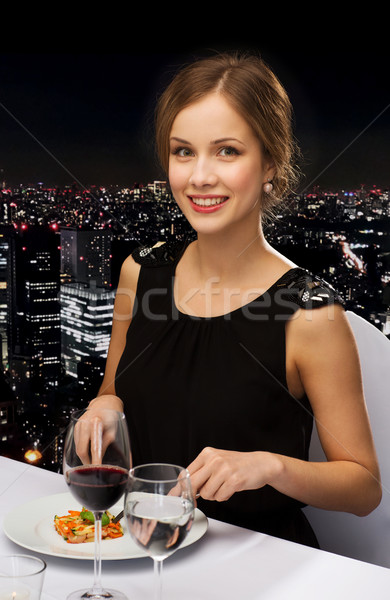 smiling young woman eating main course Stock photo © dolgachov