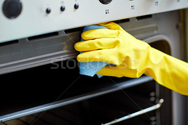 close up of woman cleaning oven at home kitchen Stock photo © dolgachov