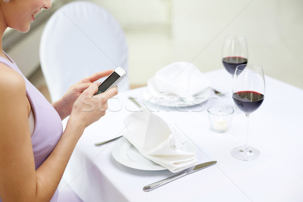 close up of woman with smartphone at restaurant Stock photo © dolgachov