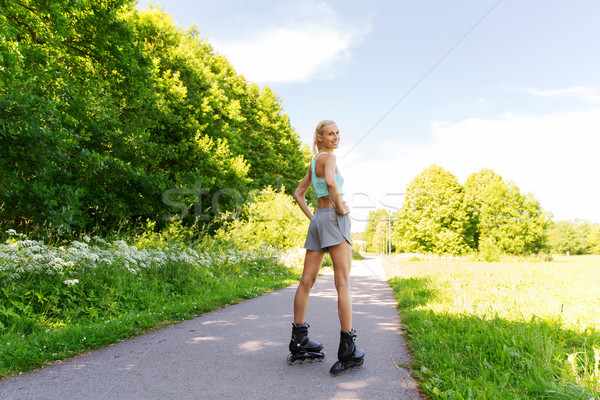 happy young woman in rollerblades riding outdoors Stock photo © dolgachov