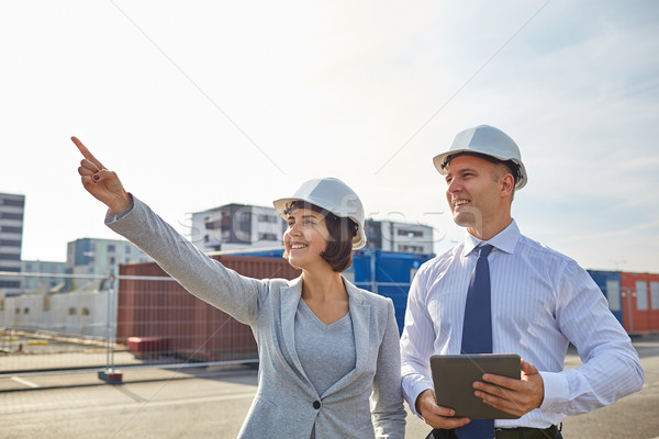 Stock photo: happy builders in hardhats with tablet pc outdoors