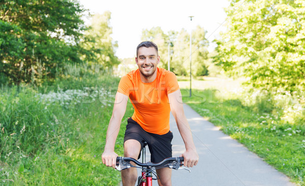 happy young man riding bicycle outdoors Stock photo © dolgachov