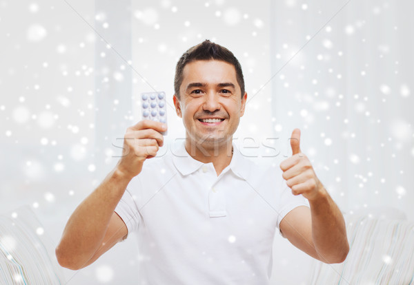 happy man with pack of pills showing thumbs up Stock photo © dolgachov
