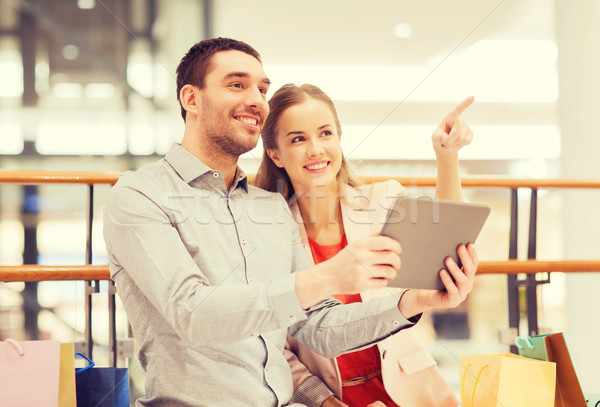 couple with tablet pc and shopping bags in mall Stock photo © dolgachov