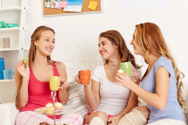 Foto stock: Feliz · las · mujeres · jóvenes · potable · té · dulces · casa