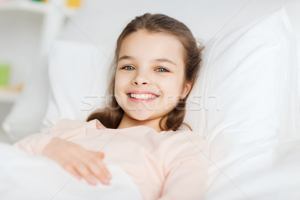 幸せ 笑みを浮かべて 少女 目が覚める ベッド ホーム ストックフォト © dolgachov