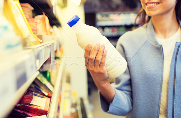Stock photo: happy woman holding milk bottle in market
