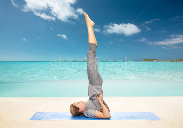 woman making yoga in shoulderstand pose on mat Stock photo © dolgachov