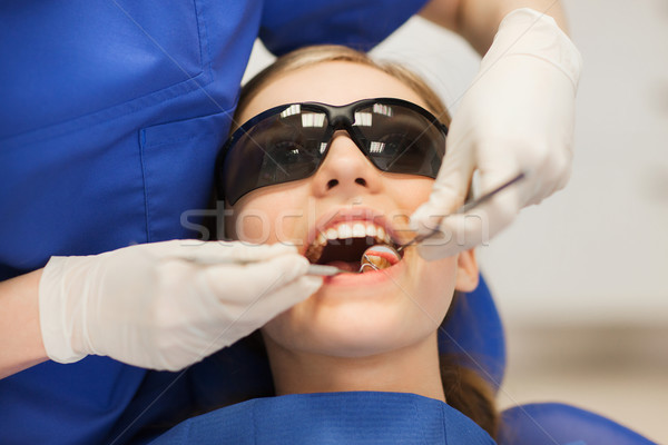 female dentist checking patient girl teeth Stock photo © dolgachov