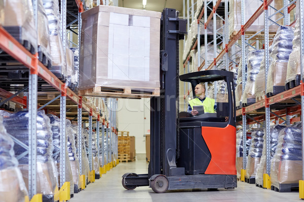 man with tablet pc operating forklift at warehouse Stock photo © dolgachov