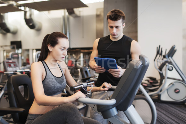 woman with trainer on exercise bike in gym Stock photo © dolgachov