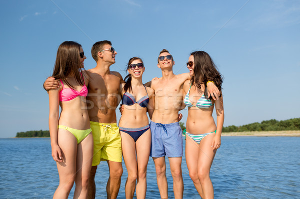 Stock photo: smiling friends in sunglasses on summer beach