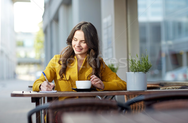 happy woman with notebook drinking cocoa at cafe Stock photo © dolgachov