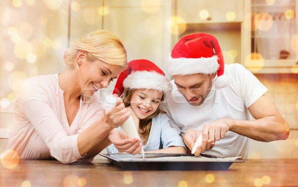 happy family in santa helper hats making cookies Stock photo © dolgachov