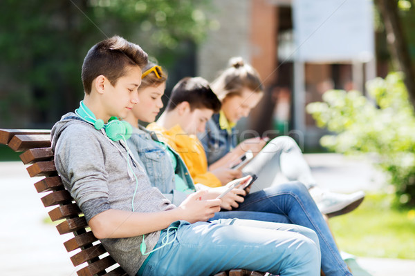 Stock photo: happy teenage boy with tablet pc and headphones