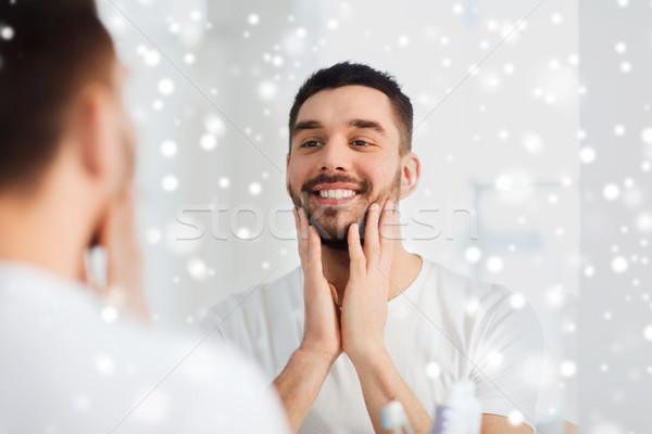 happy young man looking to mirror at home bathroom Stock photo © dolgachov