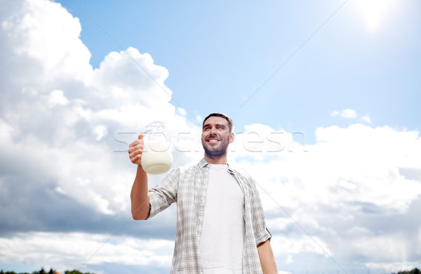 man or farmer with jug of milk at countryside Stock photo © dolgachov