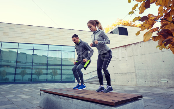 Stock photo: man and woman exercising on bench outdoors