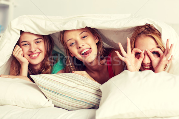 happy young women in bed at home pajama party Stock photo © dolgachov