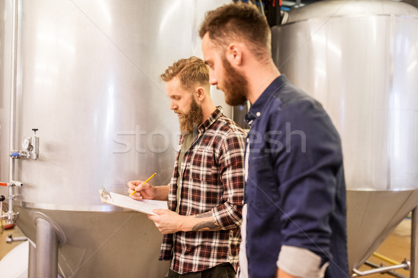 men with clipboard at craft brewery or beer plant Stock photo © dolgachov