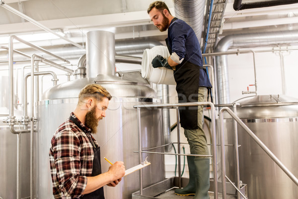 men working at craft brewery or beer plant Stock photo © dolgachov