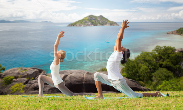 couple making yoga in low lunge pose outdoors Stock photo © dolgachov