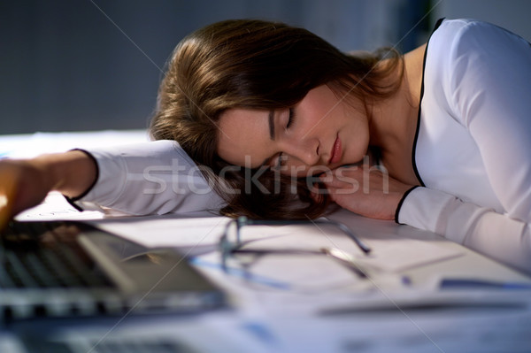 tired woman sleeping on office table at night Stock photo © dolgachov