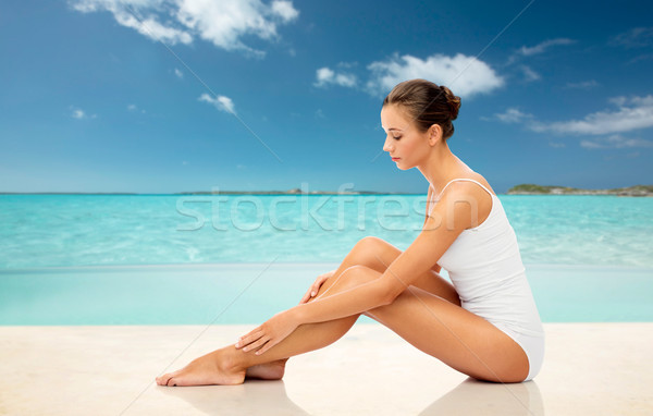 Belle femme toucher jambes plage beauté [[stock_photo]] © dolgachov