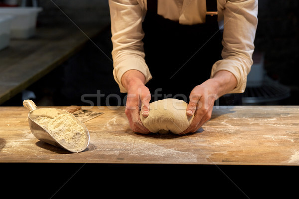 baker making bread dough at bakery kitchen Stock photo © dolgachov