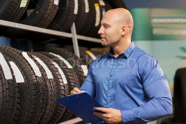 auto business owner and wheel tires at car service Stock photo © dolgachov