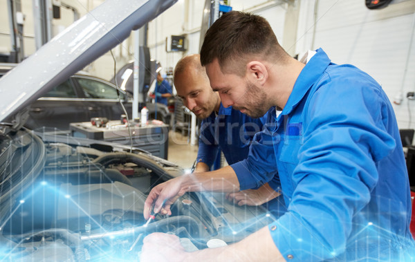 Stock photo: mechanic men with wrench repairing car at workshop